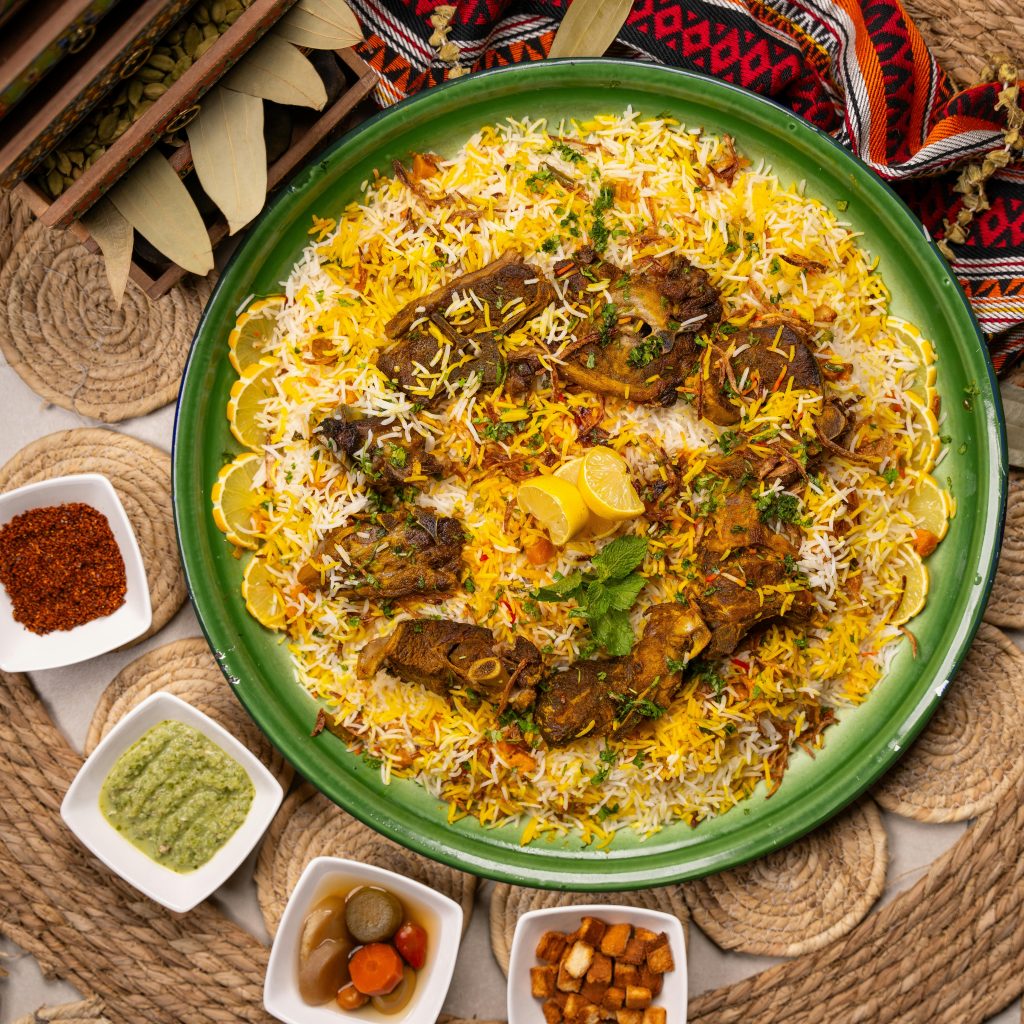 Traditional mutton biryani served with lemon wedges and perfect presentation