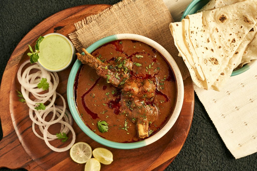 Mutton curry gravy with juicy pieces served with warm naan