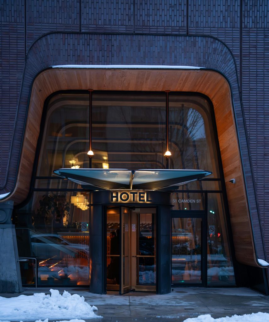 A sleek, modern hotel entrance in winter, showcasing unique architecture on Camden St, Toronto.